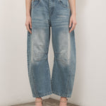 Model is wearing Good Luck Barrel Jeans in Washed Denim - front view