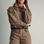 Front view of model wearing Miou Muse cocoa-brown jacket with black polka dots
