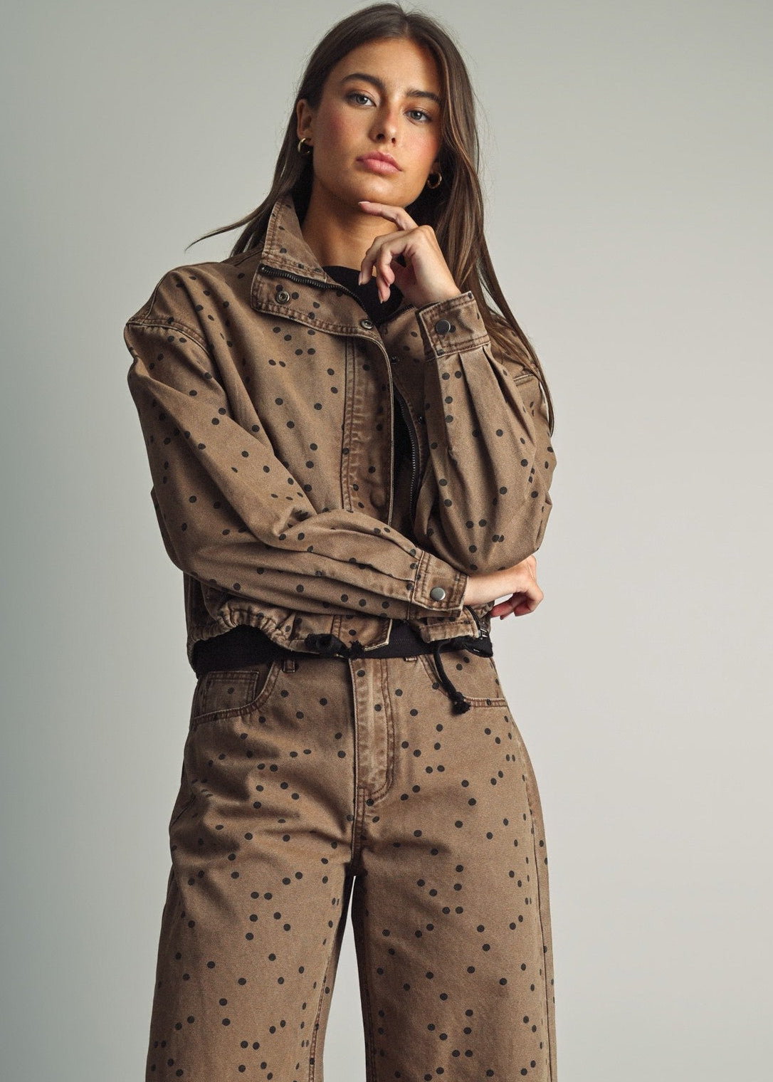 Front view of model wearing Miou Muse cocoa-brown jacket with black polka dots