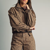 Front view of model wearing Miou Muse cocoa-brown jacket with black polka dots