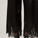 Lower-leg detail of Heirloom black satin pants showing the wide cut and delicate lace hems.