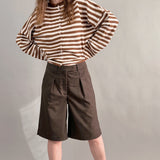 Woman wearing Hailey Button Down Cardigan in Ivory Brown Stripe styled with brown shorts, full outfit front view