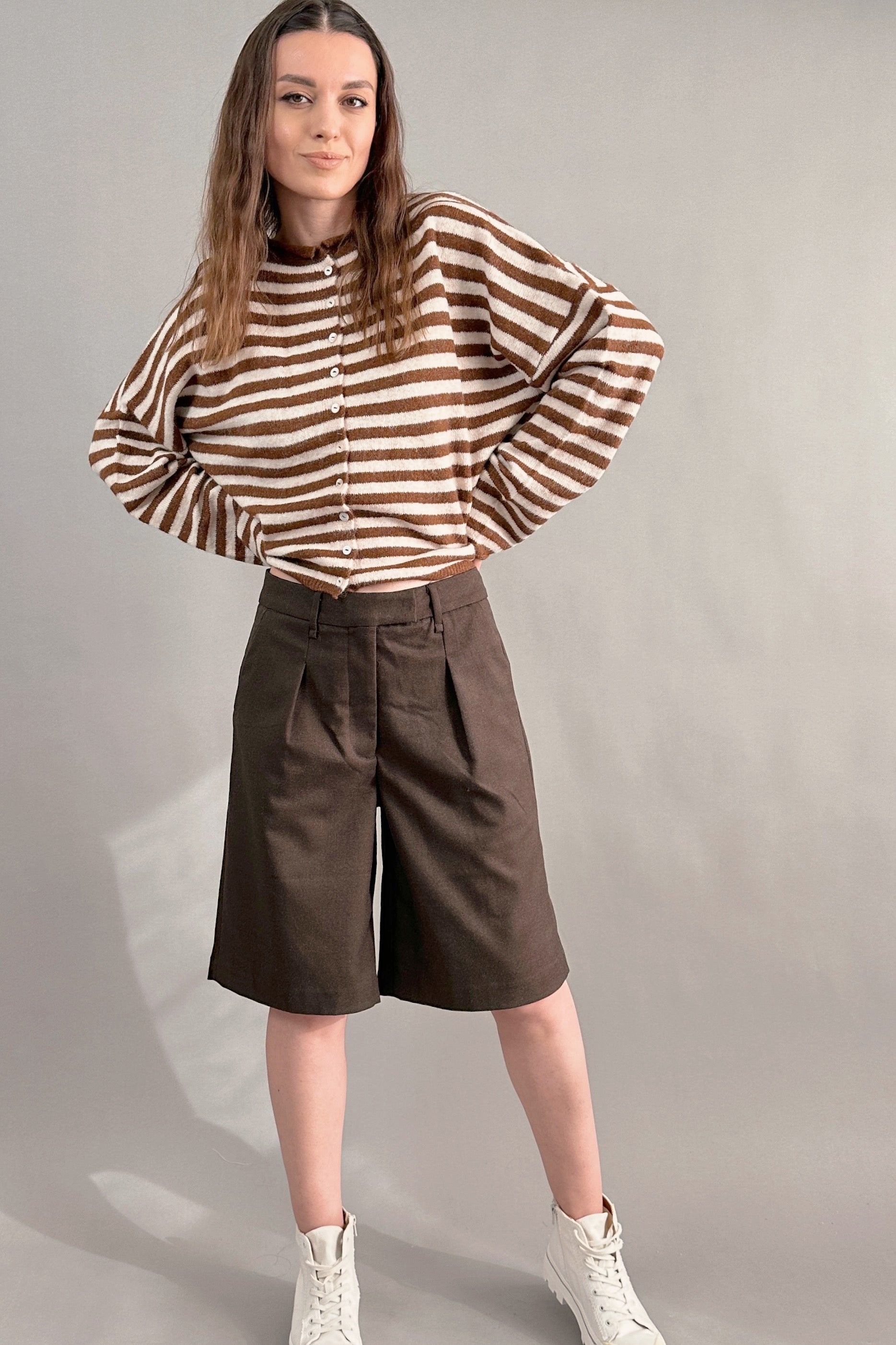 Woman wearing Hailey Button Down Cardigan in Ivory Brown Stripe styled with brown shorts, full outfit front view