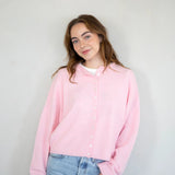 model is wearing Hailey button down cardigan (piper cardigan) in baby pink - front view