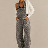 Aaron & Amber barrel-leg denim overalls in washed black with white polka dots, front view