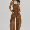 Full-length studio view of Aaron & Amber brown polka dot denim overalls with curved barrel legs