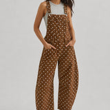 Full-length studio view of Aaron & Amber brown polka dot denim overalls with curved barrel legs