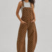 Full-length studio view of Aaron & Amber brown polka dot denim overalls with curved barrel legs