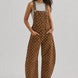 Full-length studio view of Aaron & Amber brown polka dot denim overalls with curved barrel legs