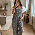 Woman wearing Aaron & Amber black polka dot barrel-leg denim overalls in a casual mirror selfie