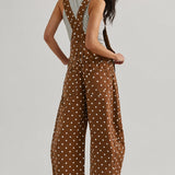 Back view of woman wearing Aaron & Amber brown polka dot barrel-leg denim overalls