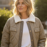 Close-up of sherpa collar and quilted fabric on olive puffer coat — soft, textured women’s outerwear.