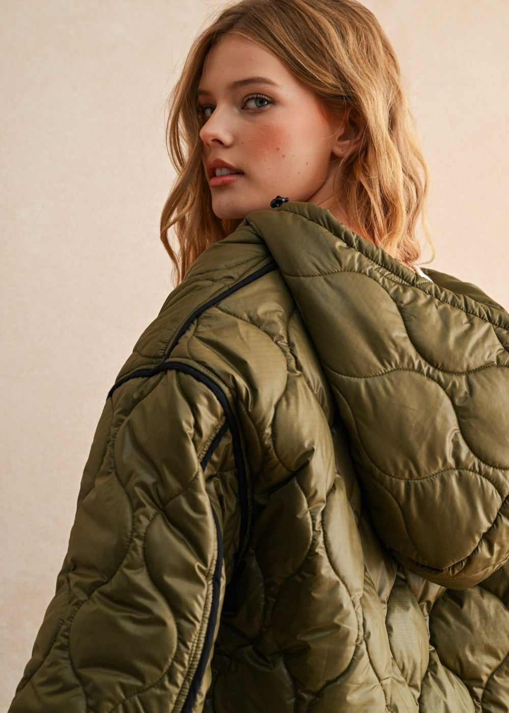 Hood view of the olive hooded quilted puffer jacket styled with jeans for everyday layering