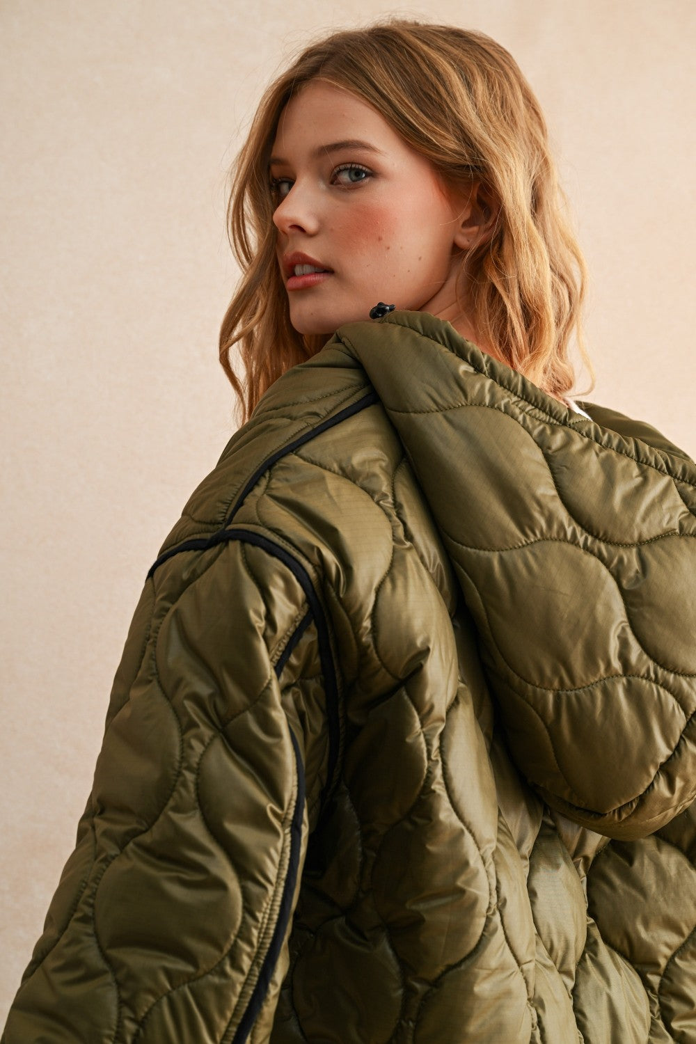 Hood view of the olive hooded quilted puffer jacket styled with jeans for everyday layering