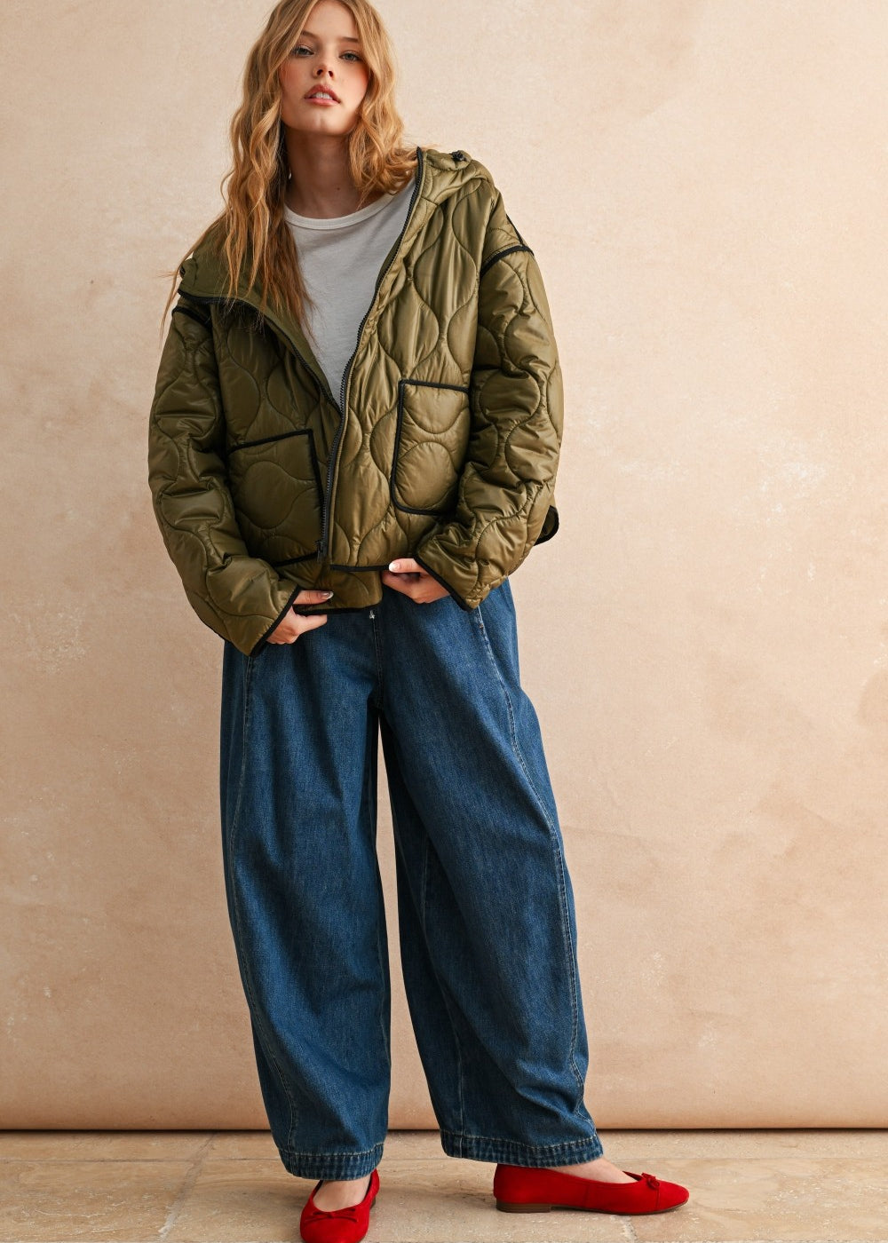 Full-body front view of model wearing the Ava Hooded Quilted Puffer Jacket in olive, relaxed fit