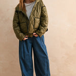 Full-body front view of model wearing the Ava Hooded Quilted Puffer Jacket in olive, relaxed fit