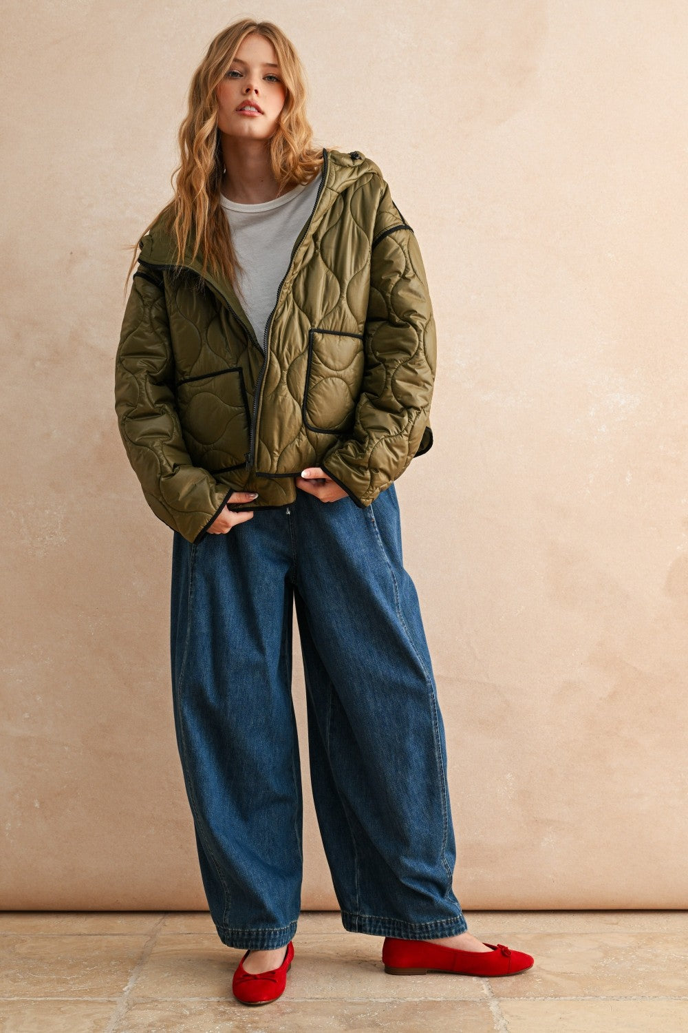 Full-body front view of model wearing the Ava Hooded Quilted Puffer Jacket in olive, relaxed fit