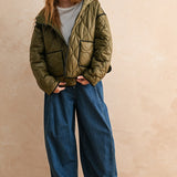 Full-body front view of model wearing the Ava Hooded Quilted Puffer Jacket in olive, relaxed fit