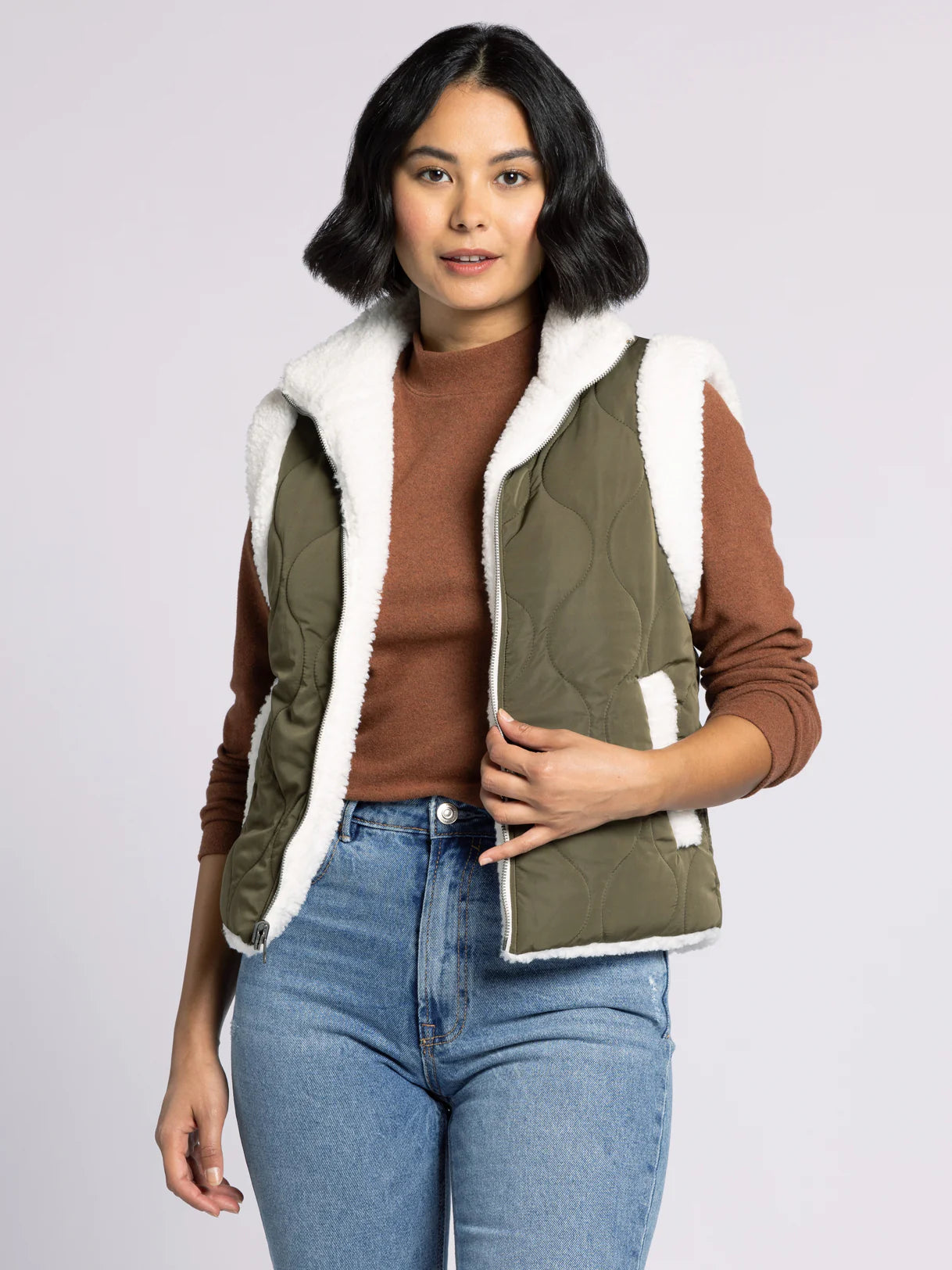 Woman wearing the Ava Reversible Quilted Sherpa Vest by Dani West — quilted side showing for a polished fall look.