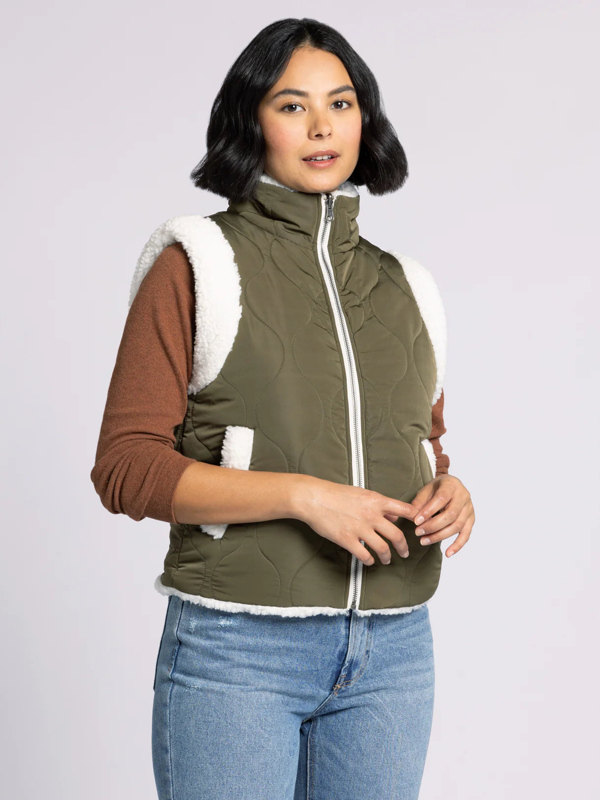 Woman wearing Ava Reversible Sherpa Vest by Dani West — soft plush sherpa side shown for casual winter style.