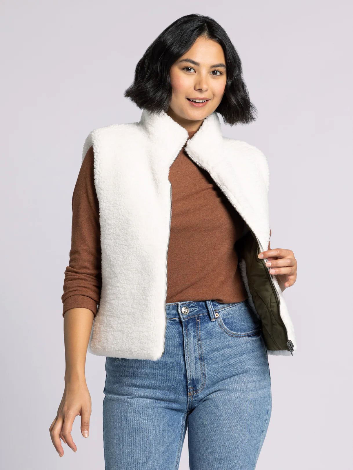 Woman wearing Ava Reversible Sherpa Vest by Dani West — soft plush sherpa side shown for casual winter style.
