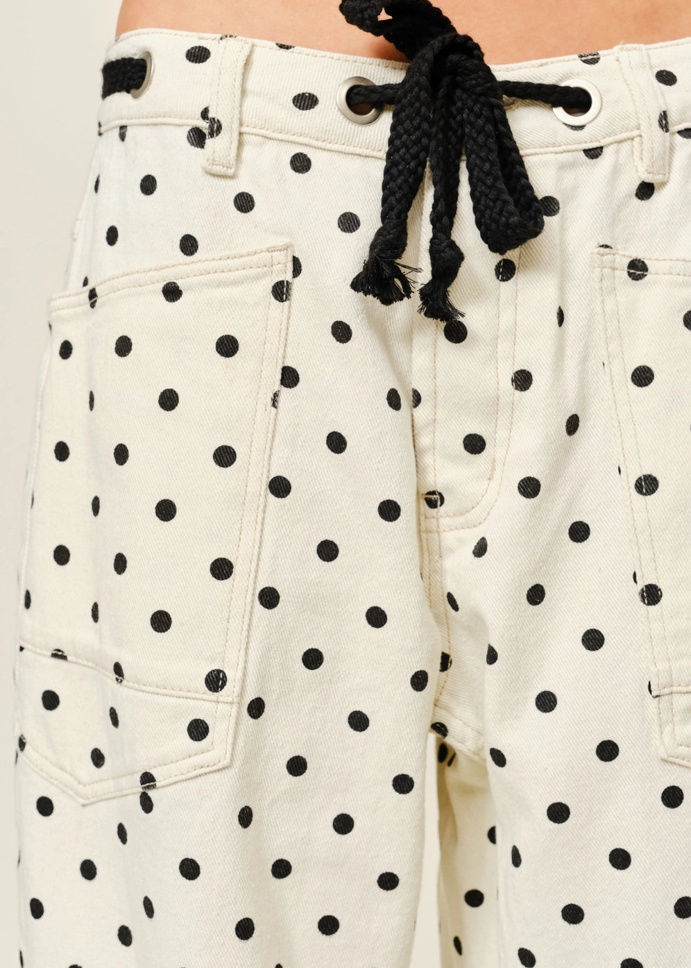 Close-up of Moxie Polka Dot Barrel Jeans in Cream showing eyelet waist and polka dot fabric
