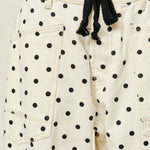 Close-up of Moxie Barrel Eyelet Jeans in polka dot cream showing eyelet waist and polka dot fabric