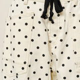 Close-up of Moxie Barrel Eyelet Jeans in polka dot cream showing eyelet waist and polka dot fabric