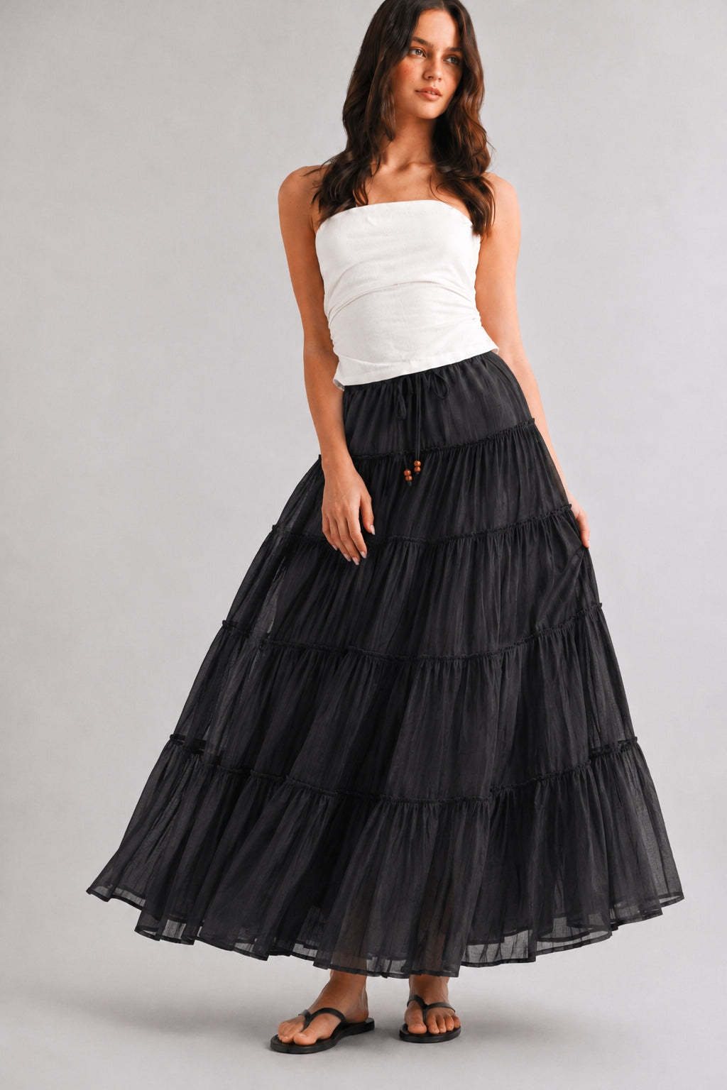 Black cotton tiered maxi skirt with a flowy A-line fit and lightweight sheer texture