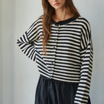 Model wearing a black and white striped knit sweater, relaxed fit, close-up front view