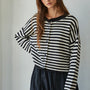 Model wearing a black and white striped knit sweater, relaxed fit, close-up front view