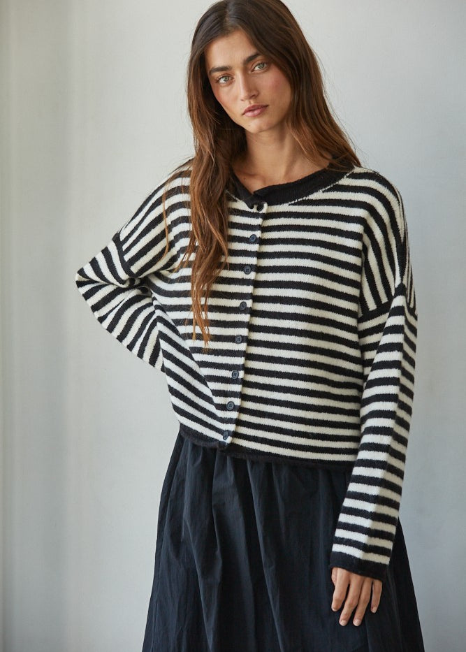 Model wearing a black and white striped knit sweater, relaxed fit, close-up front view