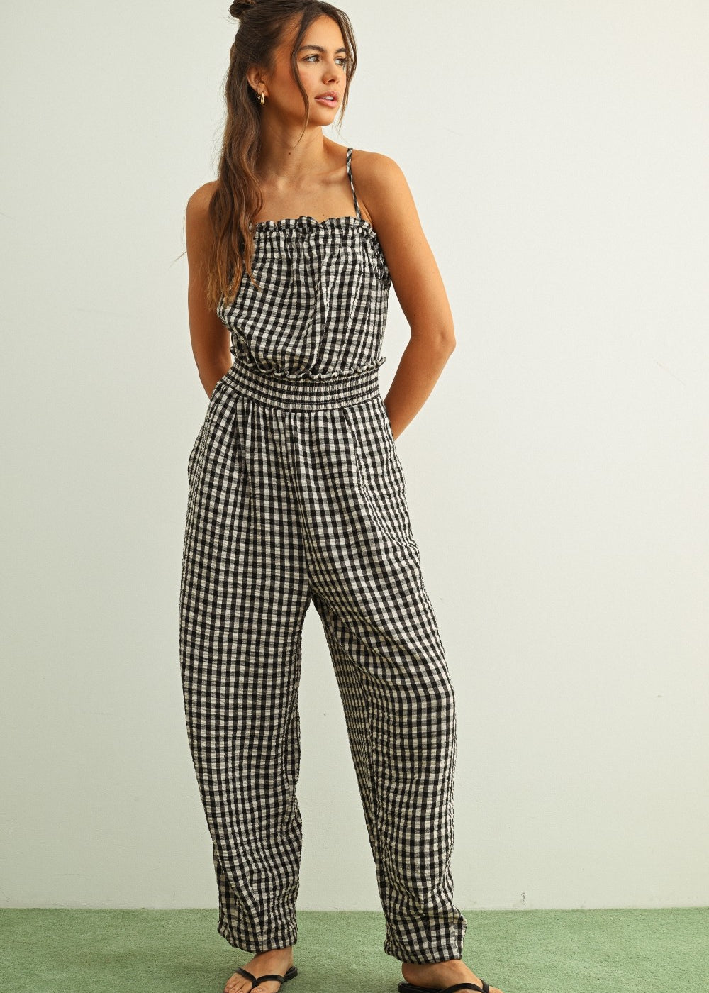 Black and white gingham smocked jumpsuit with barrel-leg fit and lightweight cotton fabric