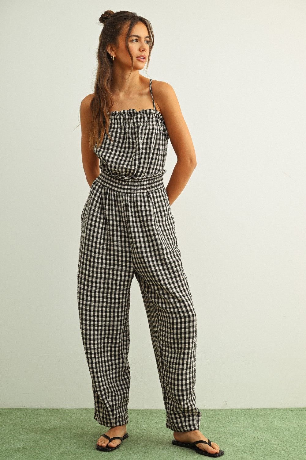 Black and white gingham smocked jumpsuit with barrel-leg fit and lightweight cotton fabric