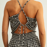 Open back detail of black and white gingham smocked jumpsuit with adjustable criss-cross straps