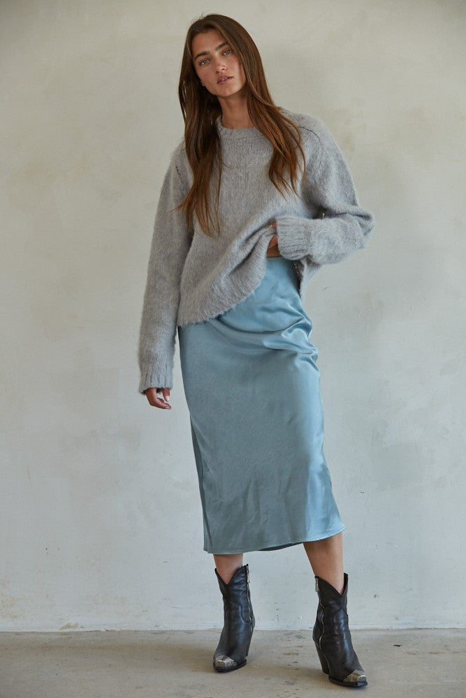 Full body view of Carly fuzzy knit pullover sweater styled with midi skirt