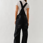Back view of chill denim overall in black wash with adjustable straps