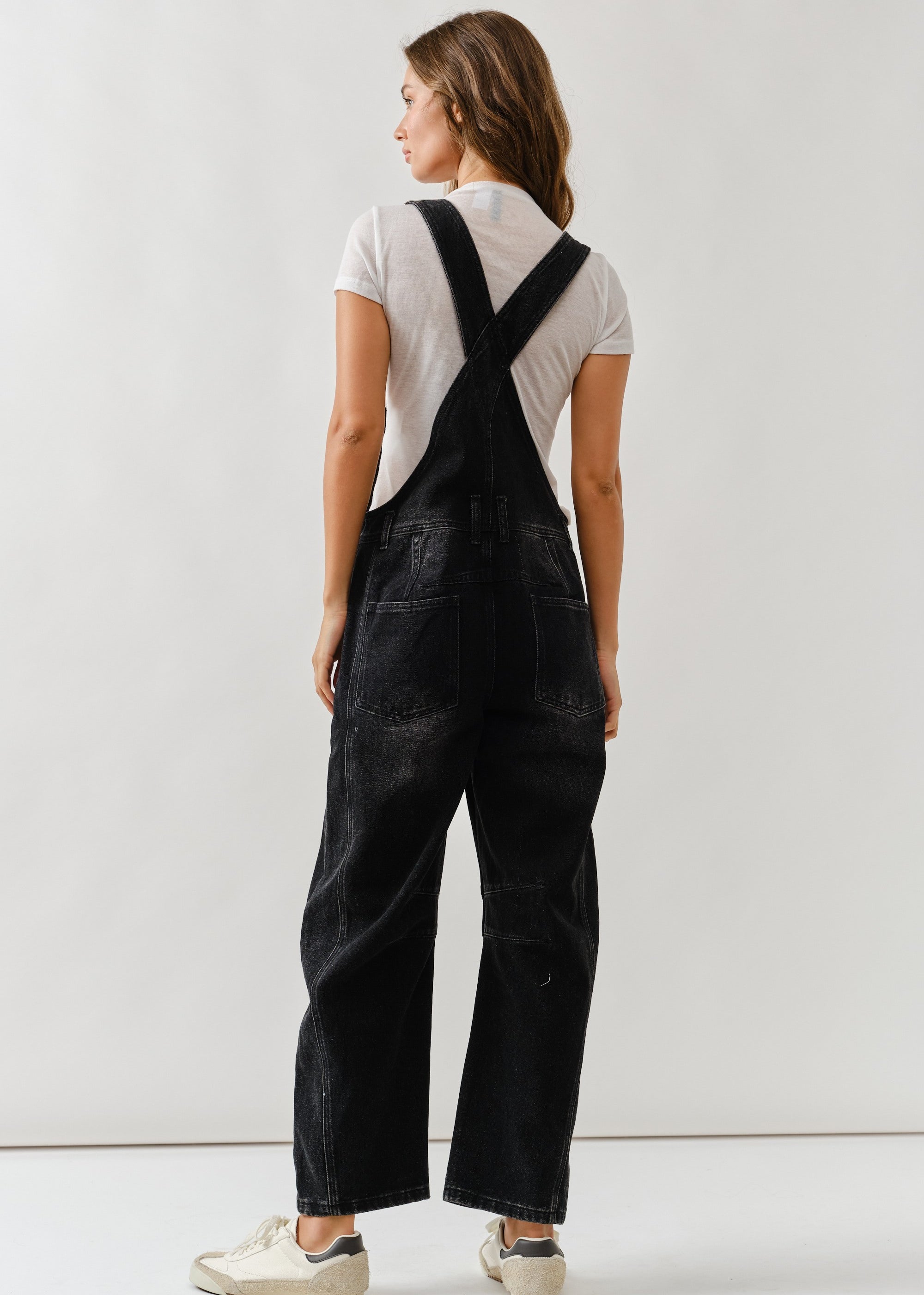 Back view of chill denim overall in black wash with adjustable straps