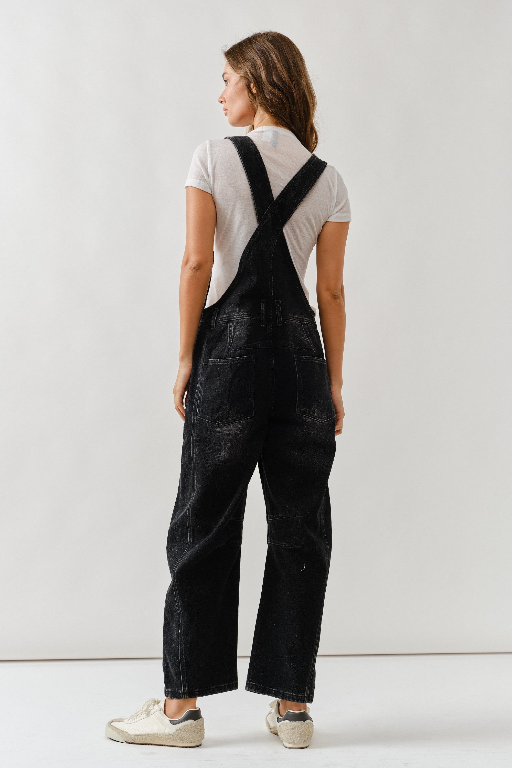 Back view of chill denim overall in black wash with adjustable straps