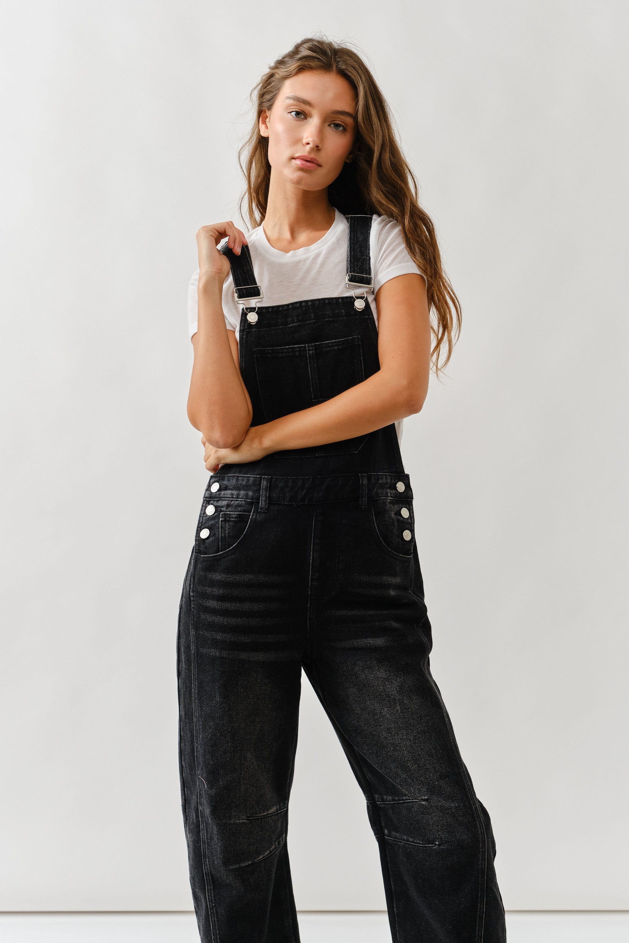 Close-up of front bib and pockets on chill denim overall in black wash