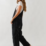 Side view of chill denim overall in black wash showing relaxed silhouette