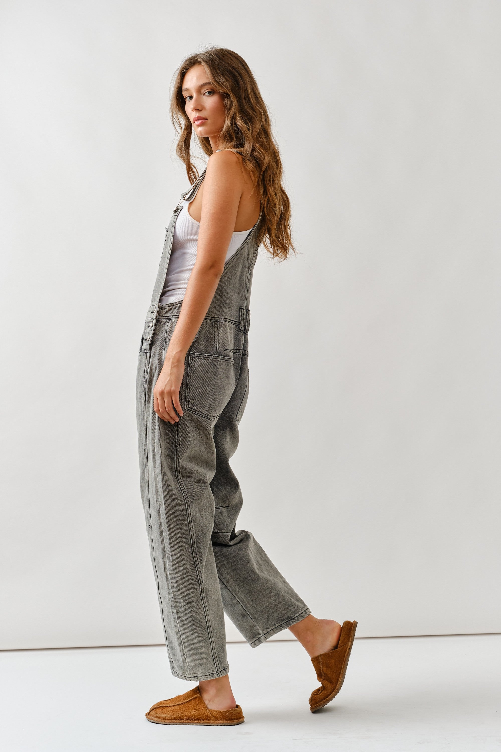Side view of chill denim overall in grey wash showing relaxed silhouette