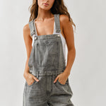 Close-up of adjustable straps and front bib on chill denim overall in grey wash