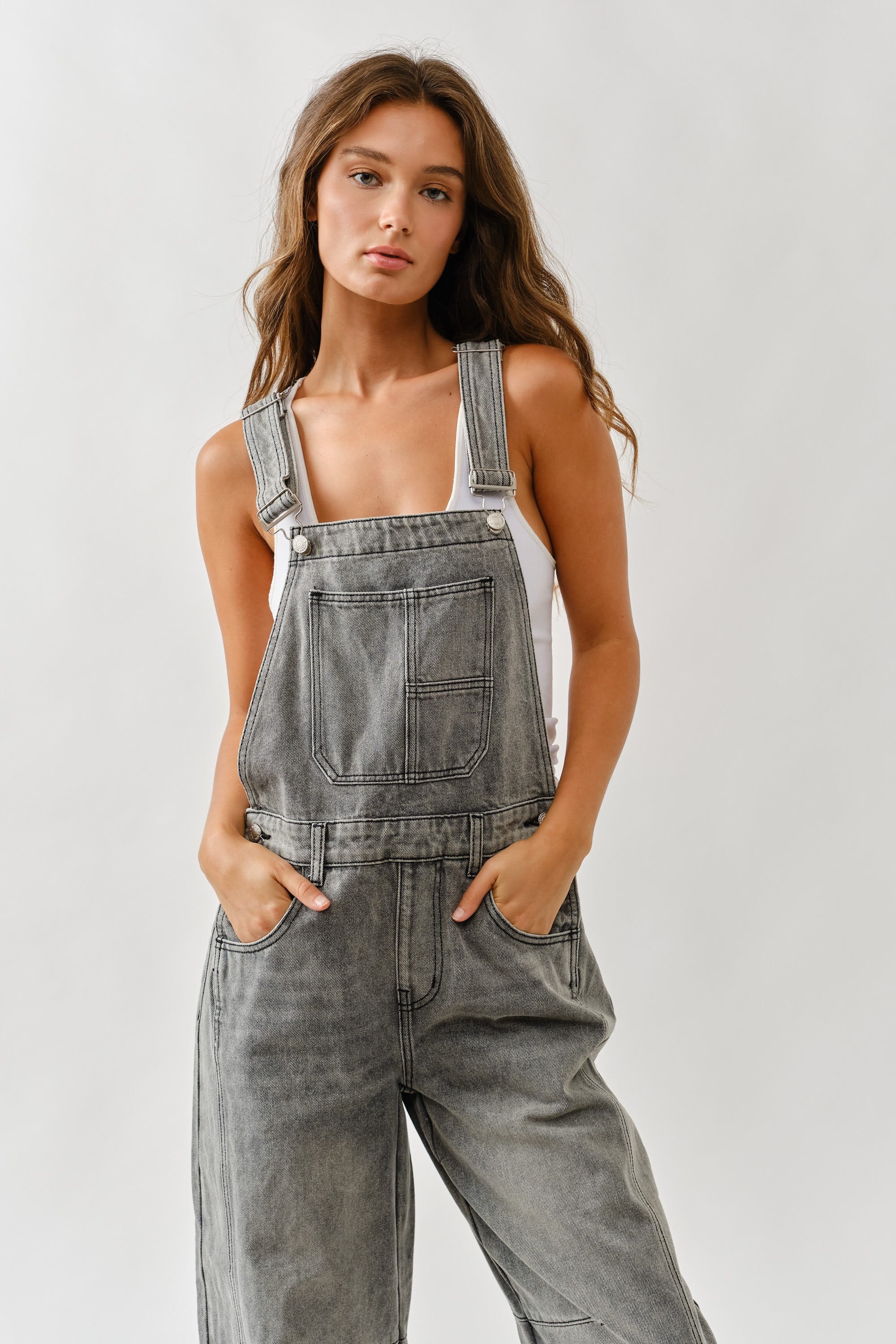 Close-up of adjustable straps and front bib on chill denim overall in grey wash