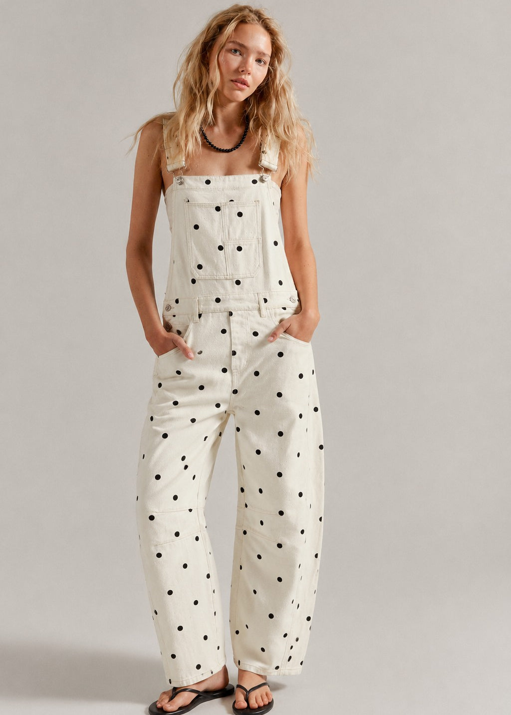 Woman wearing  Aaron & Amber Barrel-Leg Denim Overalls in Cream Polka Dot - front view