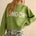 Person wearing a green sweater with 'LONDON' text on a beige background