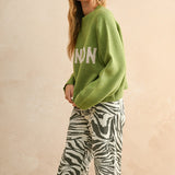 Side view of the City Print Casual Sweater in London green highlighting drape and silhouette