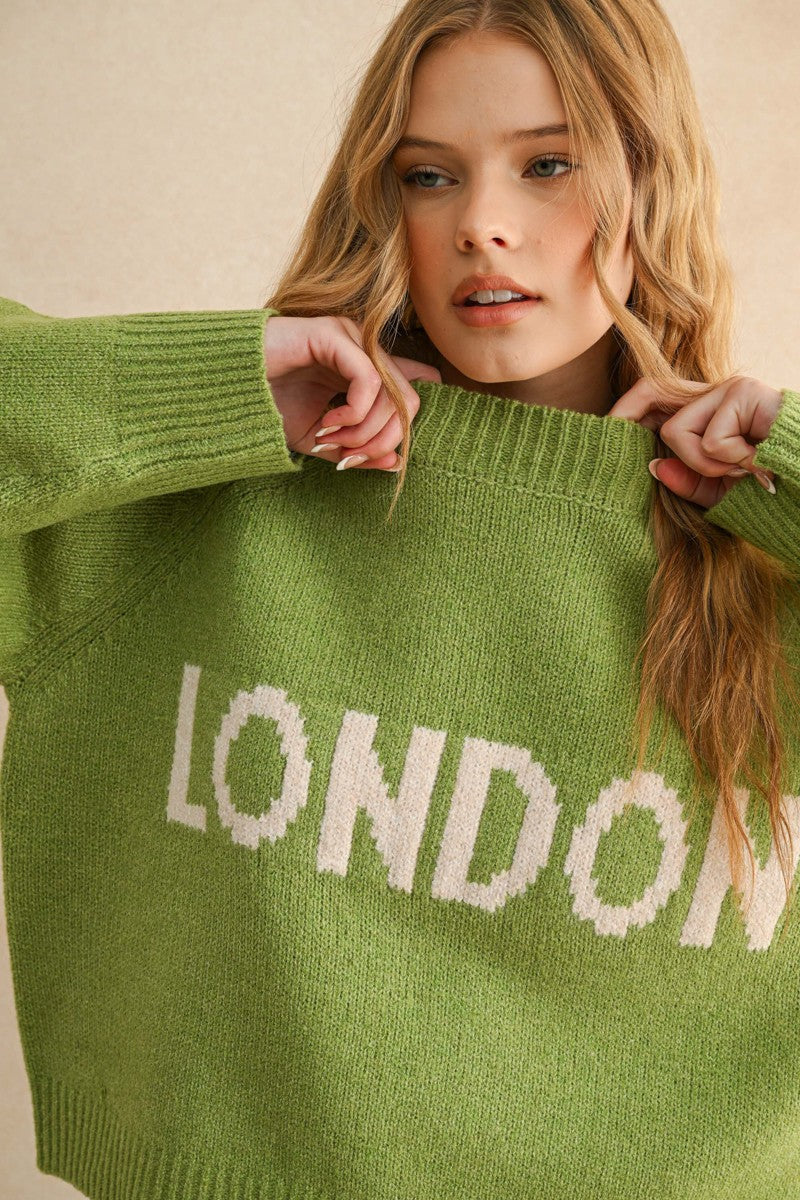 Close-up detail of the London city print on the green casual sweater
