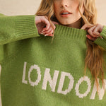 Close-up detail of the London city print on the green casual sweater