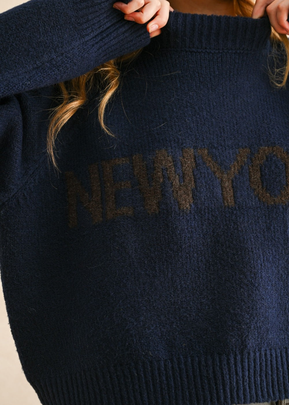 Close-up detail of the New York city print on the navy casual sweater